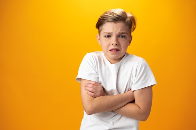 Adolescente infeliz nervioso disgustado con algo sobre fondo amarillo