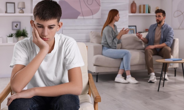 Adolescente infeliz sentado na poltrona enquanto seus pais discutem sobre problemas de fundo em casa