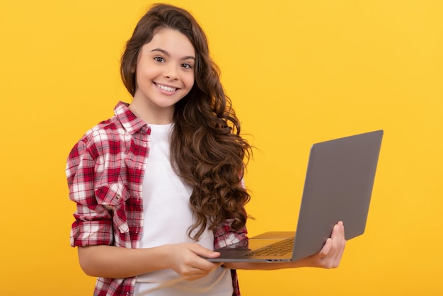 Una adolescente inteligente feliz sostiene una computadora portátil durante la lección en línea de la escuela tecnología inalámbrica