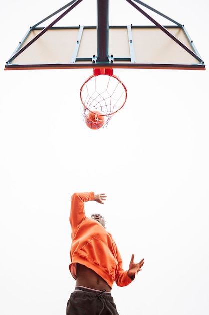 Adolescente jogando basquete ao ar livre