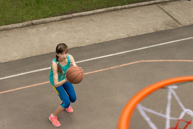 Foto adolescente jogando uma bola de basquete