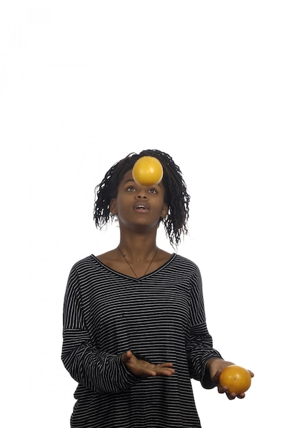 Foto adolescente jugando con una naranja,