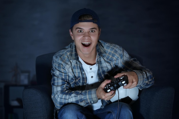 Adolescente jugando videojuegos en casa tarde en la noche