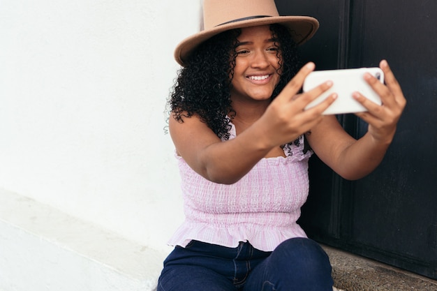 Adolescente latina tirando uma selfie com o telefone