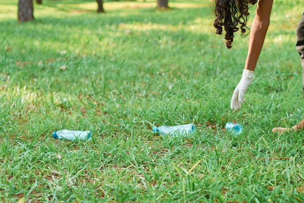 Adolescente latino voluntario recoge basura del bosque para reciclar plástico