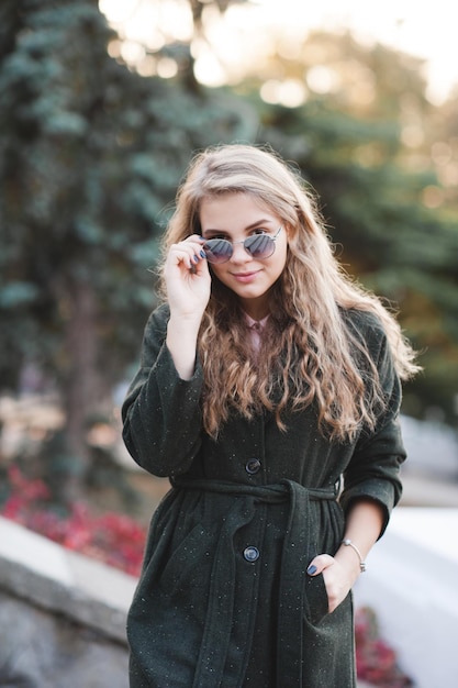 Adolescente loira elegante usando jaqueta de primavera e óculos de sol