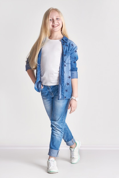 Adolescente loira em uma fantasia de jeans, diversão infantil fashionrt posando