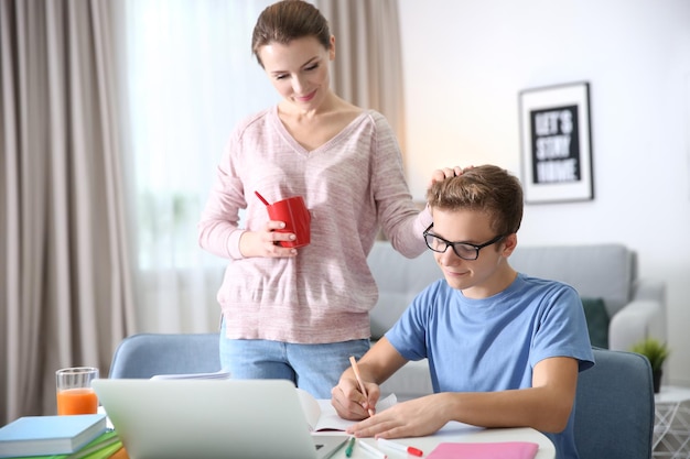 Adolescente con madre haciendo la tarea en casa