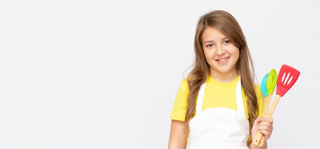 Adolescente menina feliz chef cozinheiro confeiteiro padeiro dona de casa em camiseta amarela ficar em casa isolada no estúdio de fundo cinza claro. conceito de cozinheiro de comida