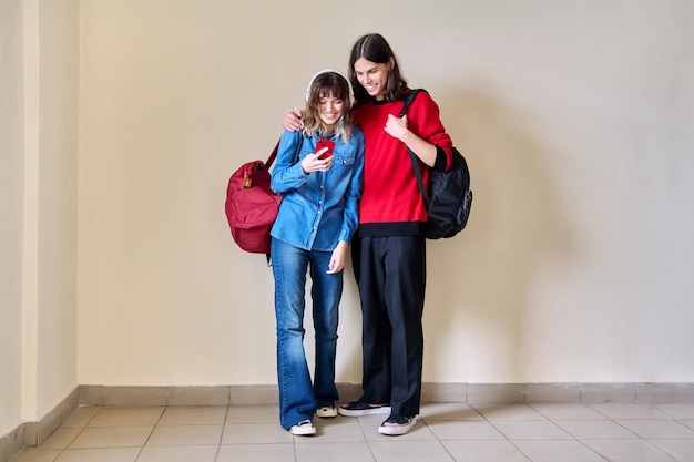 Adolescente menino e menina olhando para smartphone juntos