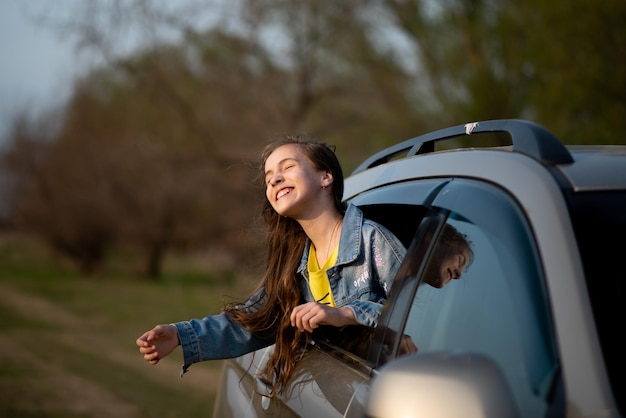 Una adolescente mira por la ventanilla del coche Journey Sunset Beauty