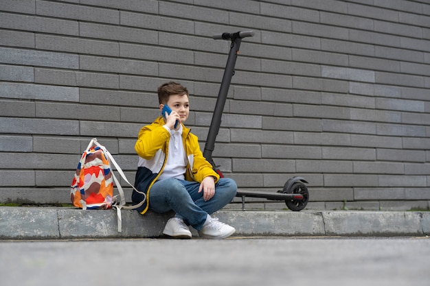 Adolescente moderno con mochila y scooter eléctrico