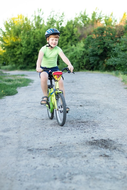 Un adolescente montando en bicicleta por un camino de ripio en verano