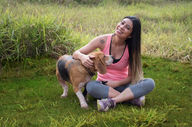 Adolescente morena com cachorro beagle no parque ao ar livre