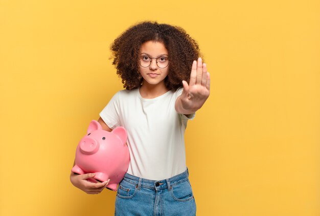 Adolescente muito afro fazendo gesto de pare. conceito de economia