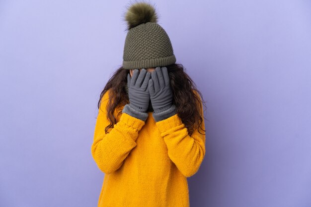 Adolescente mujer rusa con sombrero de invierno aislado en la pared púrpura con expresión cansada y enferma