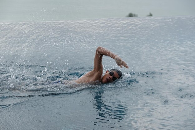 Un adolescente nadando en una piscina infinita