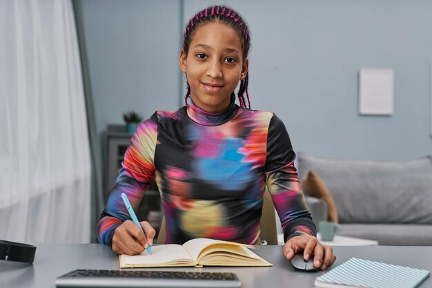 Adolescente negra estudando em casa