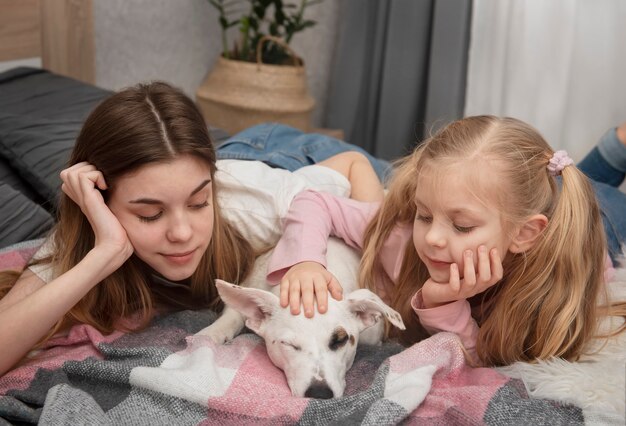 Adolescente y niño jugando con su perro jack russell