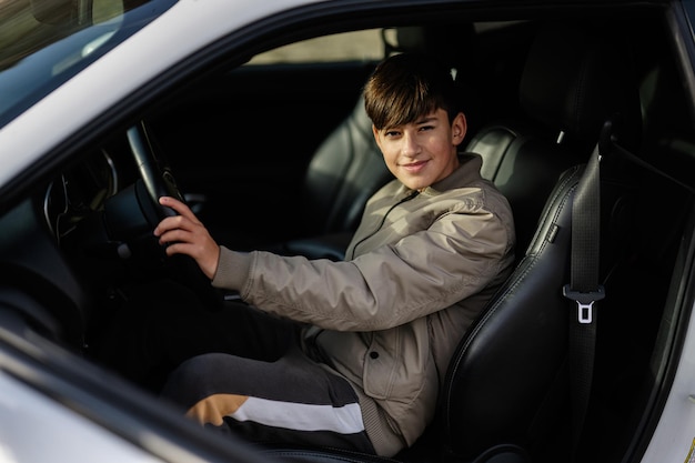 adolescente, niño, sentarse, en, coche del músculo, joven, adolescente, conductor