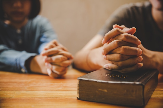 adolescente orando junto com a Bíblia em casa