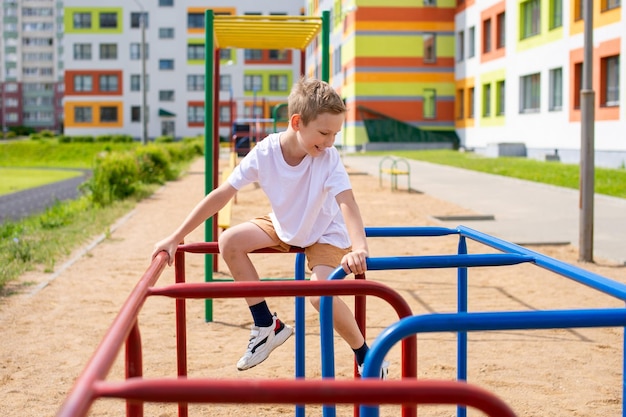 Un adolescente participa en barras horizontales cerca de la escuela.