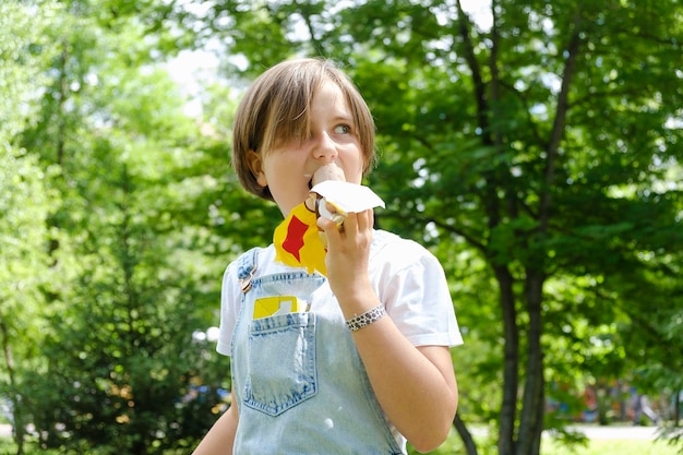 Una adolescente en un paseo en un día de verano en el parque para disfrutar de un helado