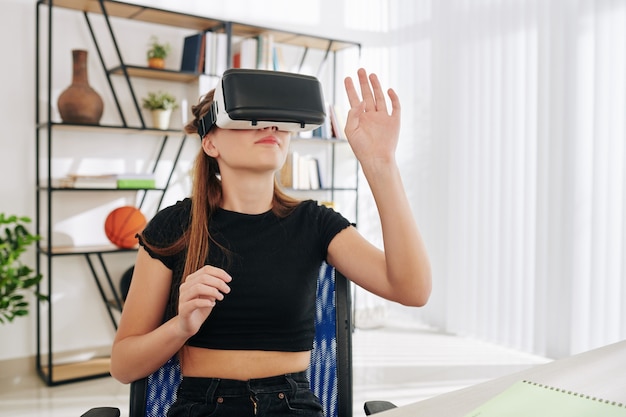 Adolescente passando o fim de semana em casa jogando com óculos de realidade virtual