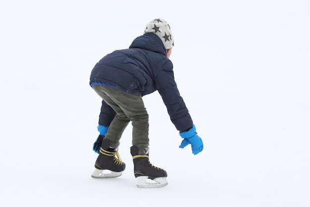 El adolescente patina en la pista de hielo.