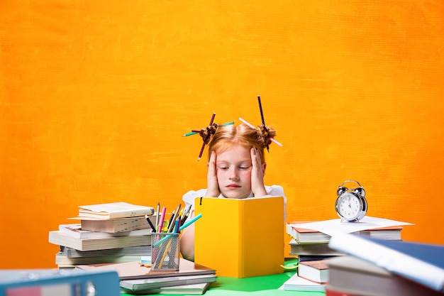 La adolescente pelirroja con muchos libros en casa. Tiro del estudio