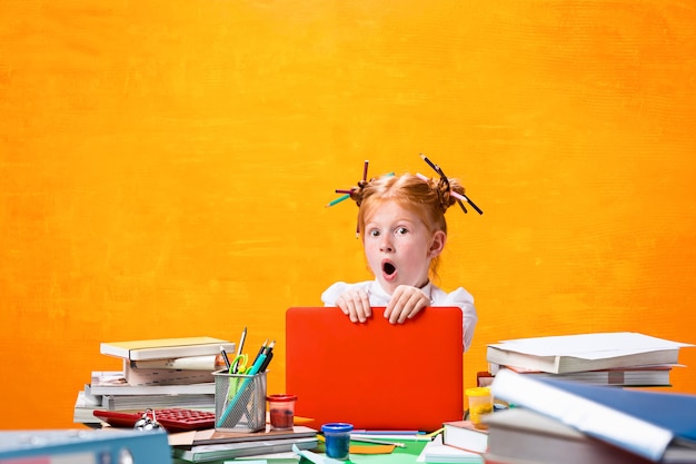 La adolescente pelirroja con muchos libros en casa. Tiro del estudio