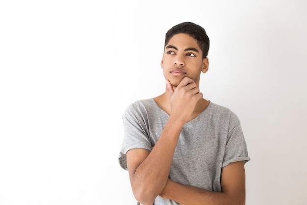 Adolescente de pensamiento atractivo, estudiante. Chico pensativo Retrato de un hombre negro afroamericano joven que piensa sobre una idea.