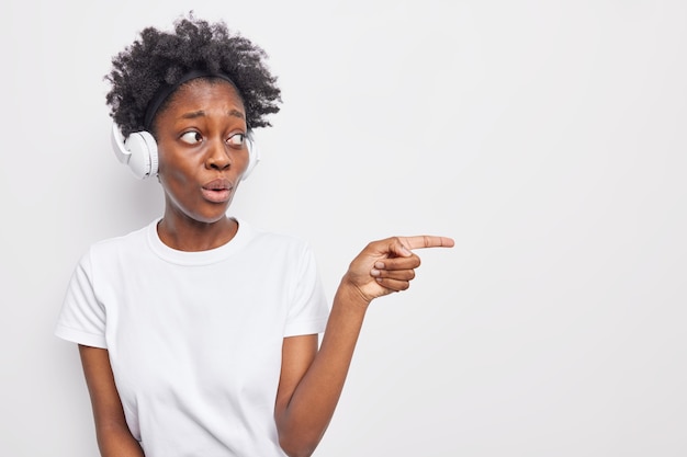 Una adolescente de piel oscura con cabello afro se encuentra conmocionado puntos en el espacio en blanco