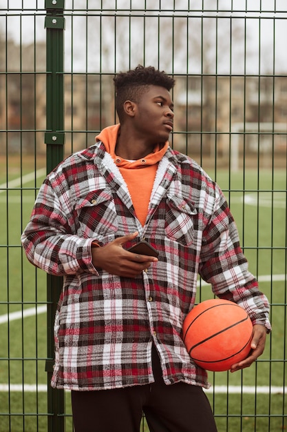 Foto adolescente posando no campo de basquete