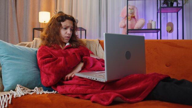 Una adolescente preadolescente usa una computadora portátil sorprendida por malas noticias pérdida de fortuna fracaso resultados de la lotería en casa