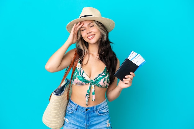 Adolescente rusa en bikini sosteniendo un pasaporte aislado sobre fondo azul se ha dado cuenta de algo y tiene la intención de la solución