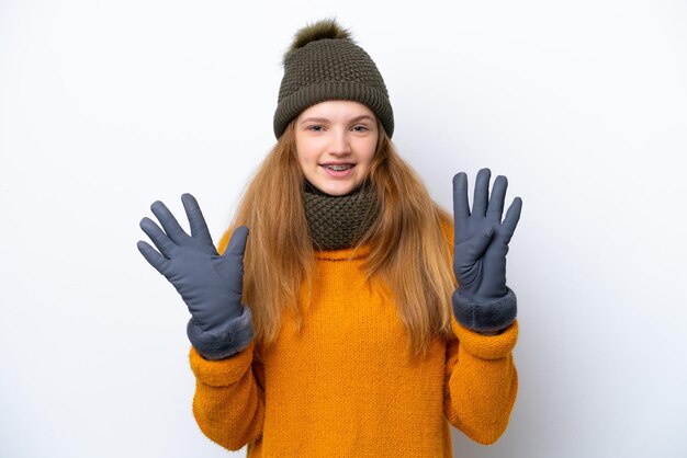 Adolescente rusa con chaqueta de invierno aislada de fondo blanco contando nueve con los dedos