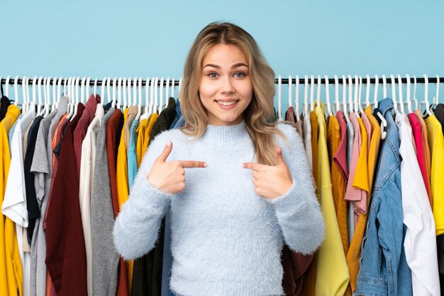 Adolescente rusa comprando algo de ropa en azul con expresión facial sorpresa