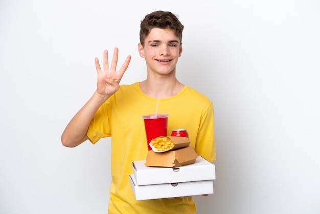 Adolescente ruso hombre sosteniendo comida rápida aislado sobre fondo blanco feliz y contando cuatro con los dedos