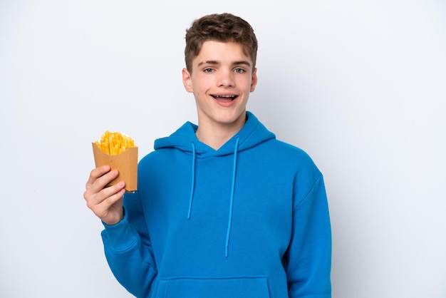 Adolescente ruso hombre sosteniendo patatas fritas aislado sobre fondo blanco con expresión facial sorpresa