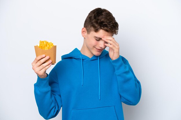Adolescente ruso hombre sujetando patatas fritas aislado sobre fondo blanco riendo