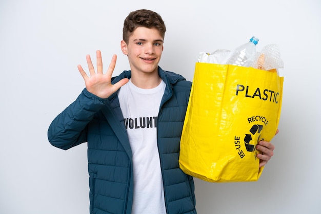 Adolescente ruso sosteniendo una bolsa llena de botellas de plástico para reciclar sobre fondo blanco contando cinco con los dedos