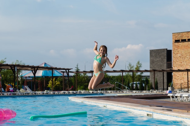 Adolescente salta en la piscina