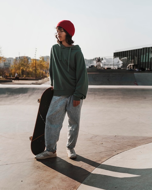 Foto adolescente se divertindo andando de skate ao ar livre no skatepark