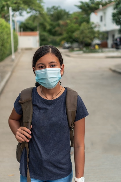 Adolescente se preparando para a escola, garota com máscara protetora saindo de casa