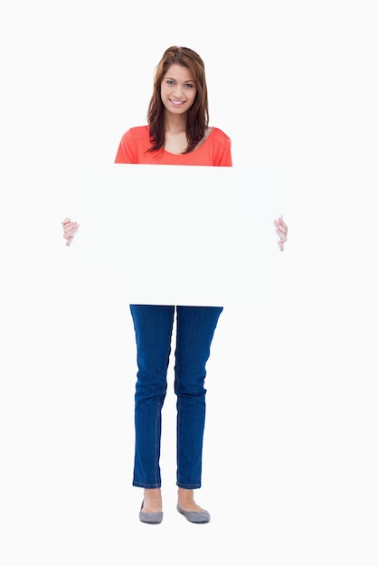Adolescente segurando um cartaz em branco sobre um fundo branco