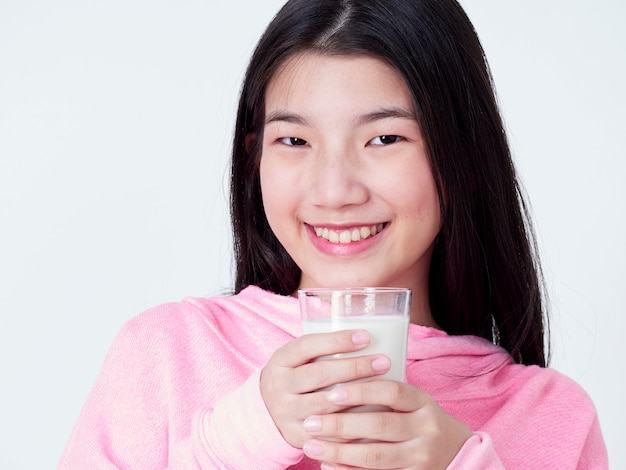 Adolescente, segurando um copo de leite.