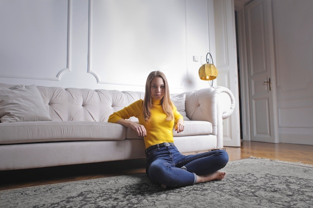 Adolescente sentado en una alfombra
