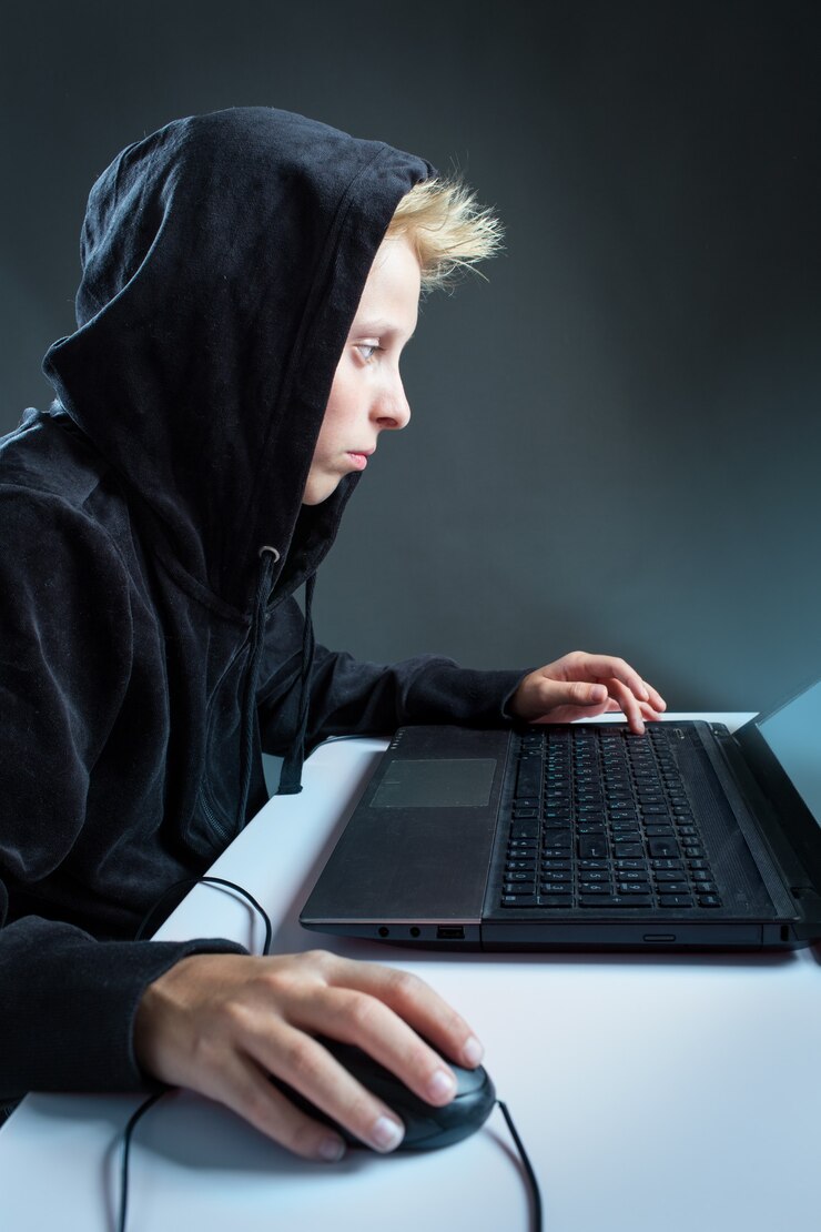 Foto adolescente sentado detrás de una computadora