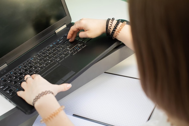 Un adolescente se sienta y escribe mientras hace la tarea